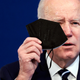 U.S. President Joe Biden holds a mask as he gives remarks in the Eisenhower Executive Office Building on January 13, 2022 in Washington, D.C.